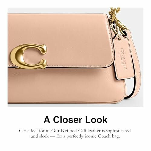 Close-up of a Coach handbag with gold hardware and tag.